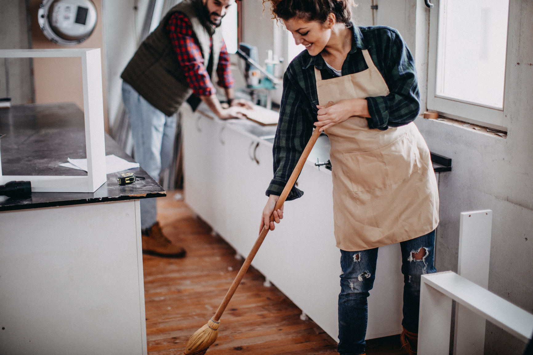 Young  couple cleaning a construction workshop